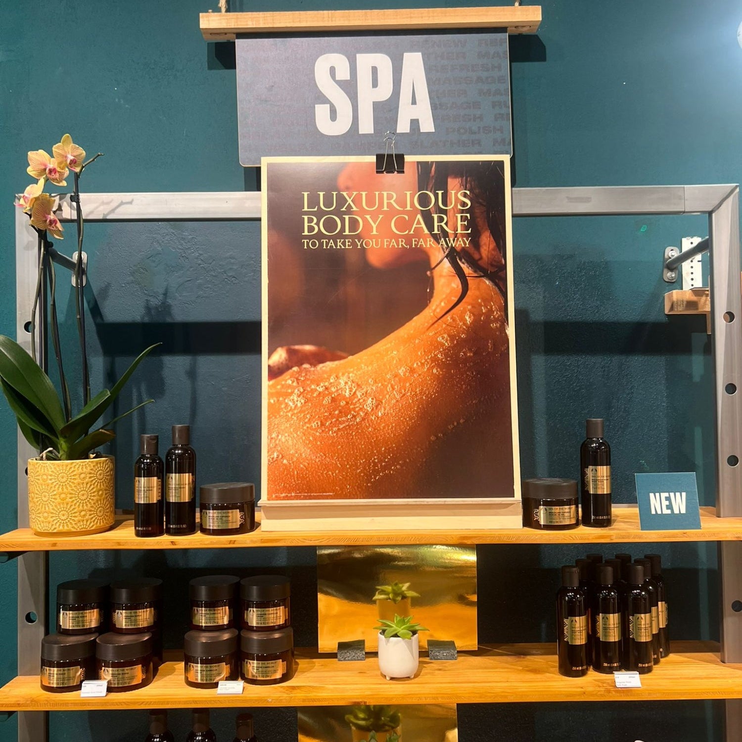 Display of luxurious body care products shot by shaded the studio with a 'SPA' poster in the background.